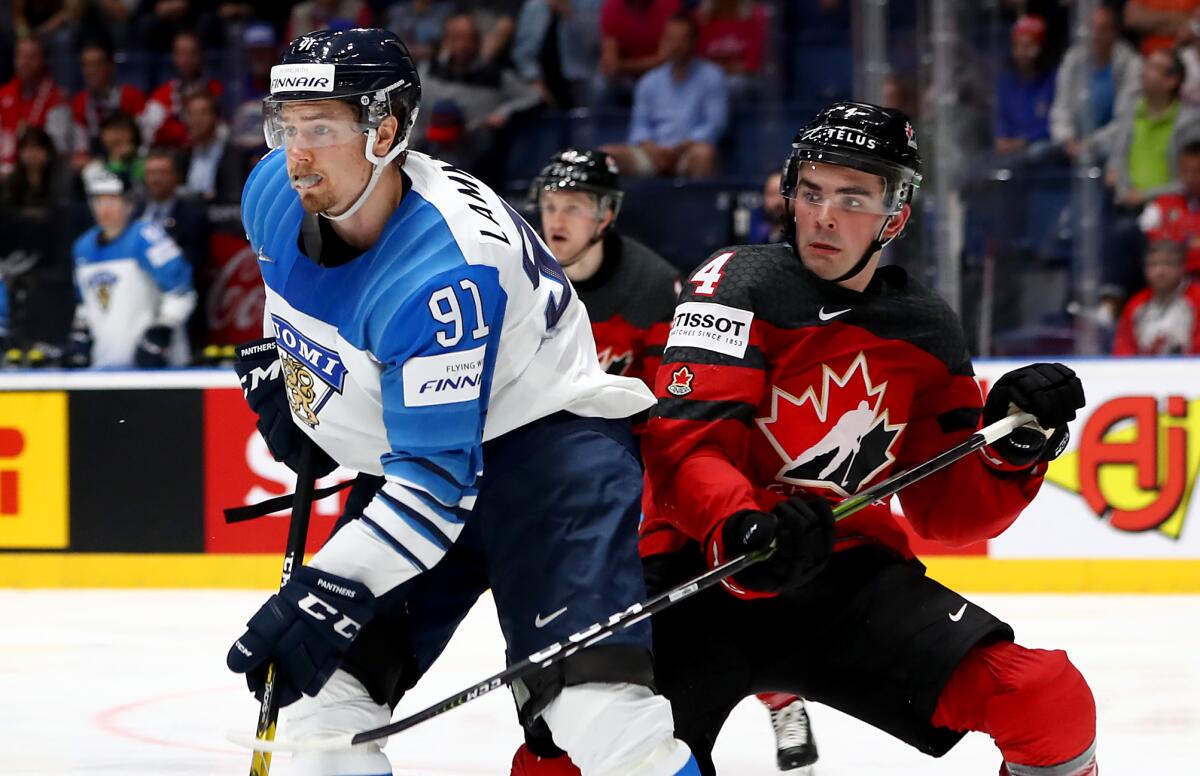 Canada's Dante Fabbro, right, defends against Finland's Juha Lammikko during the 2019 IIHF championship game.