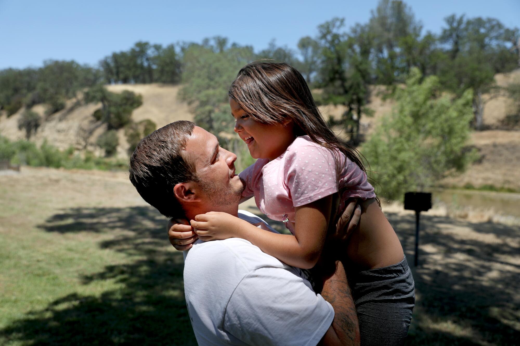 A man embraces his daughter.