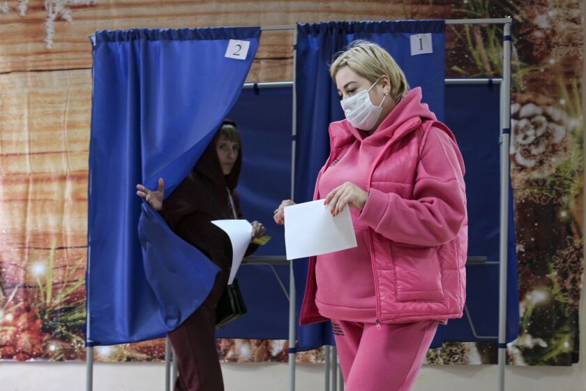 Unas personas emiten su voto en un referendo, el martes 27 de septiembre de 2022, en Donetsk, Ucrania. (AP Foto)