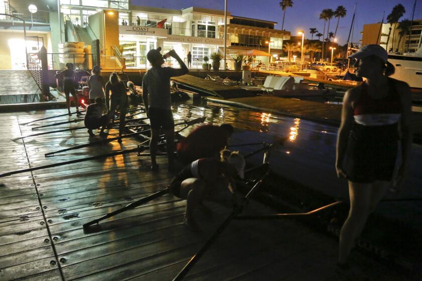 Team members of the Newport Sea Base Rowing Club gather before sunrise to launch their boats in Newport Harbor. Rowing, which includes sweep boats that use single-sided oars and sculls with double oars, has solo and two-man boats but is overwhelmingly a team sport.