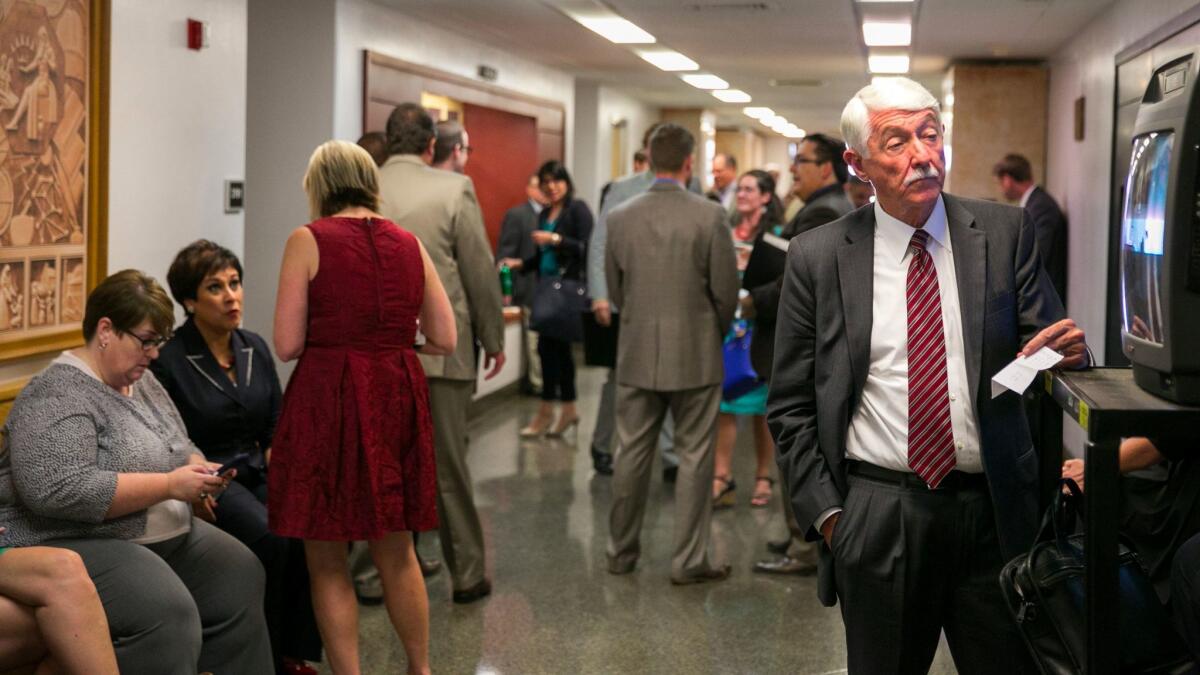 There are more than 1,800 registered lobbyists seeking to influence California government, some of them seen here in the hallway of the State Capitol, in Sacramento last fall.