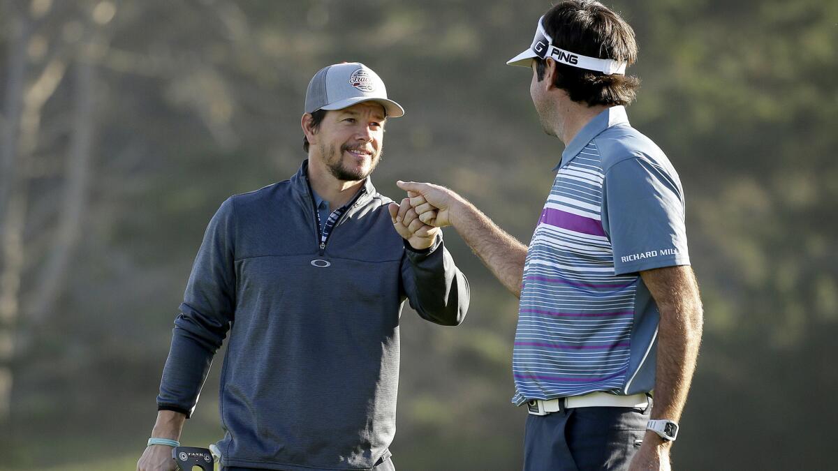 Mark Wahlberg and Bubba Watson fist-bump after Watson made a birdie at No. 2 on Spyglass Hill in the first round of the Pebble Beach Pro-Am on Thursday.