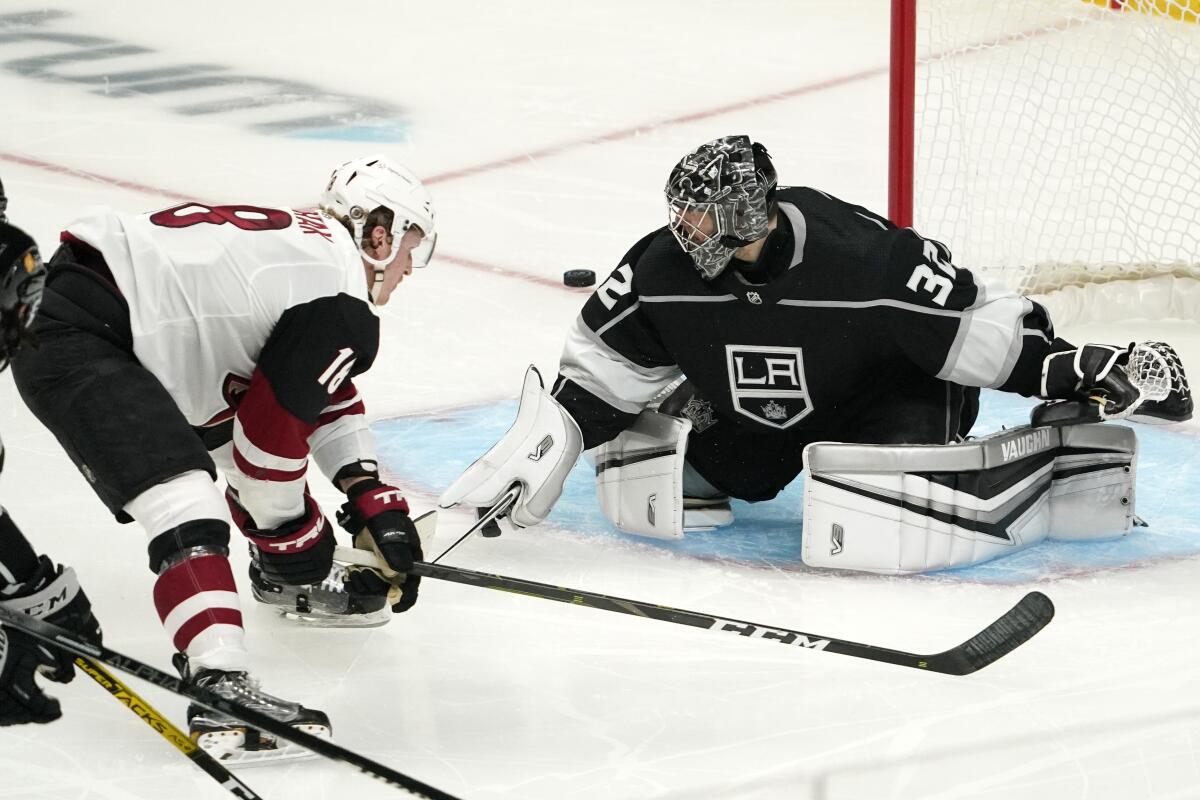 Arizona Coyotes center Christian Dvorak, left, shoots wide in front of Kings goaltender Jonathan Quick.