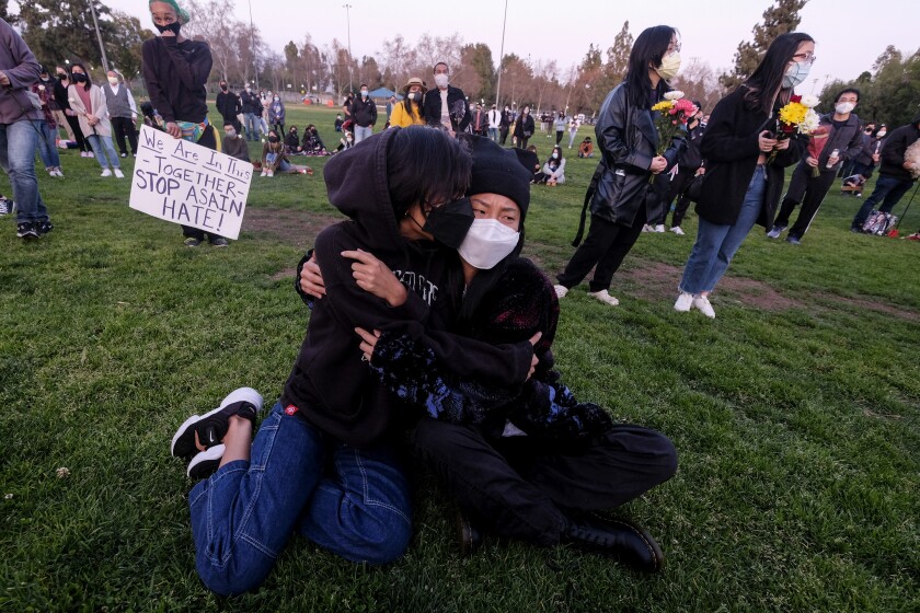 Two people hug at a candlelight vigil against anti-Asian violence in Alhambra
