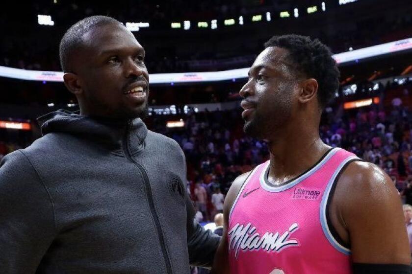Minnesota Timberwolves forward Luol Deng, left, talks with Miami Heat guard Dwyane Wade (3) after an NBA basketball game, Sunday, Dec. 30, 2018, in Miami. The Timberwolves won 113-104. (AP Photo/Lynne Sladky)