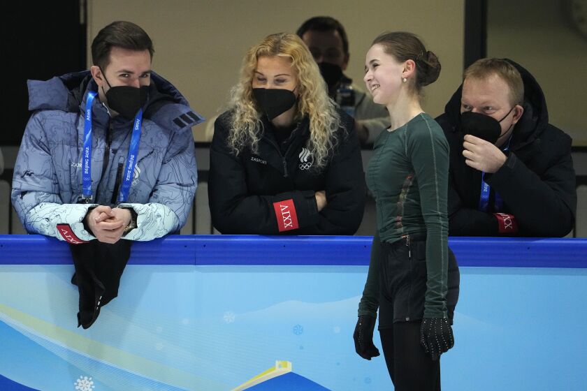 Kamila Valieva, of the Russian Olympic Committee, talks to coaches at a training session at the 2022 Winter Olympics, Thursday, Feb. 10, 2022, in Beijing. (AP Photo/Jeff Roberson)