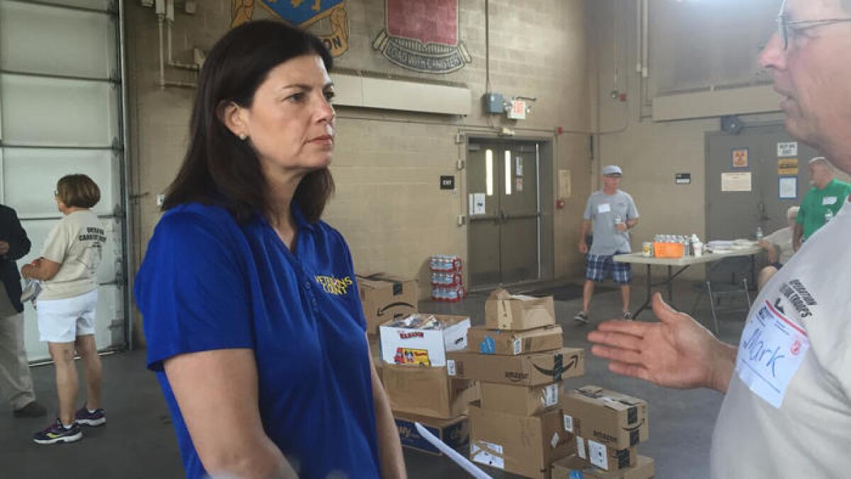 Sen. Kelly Ayotte visits with volunteers packaging care boxes for U.S. troops as she campaigns for reelection in New Hampshire.