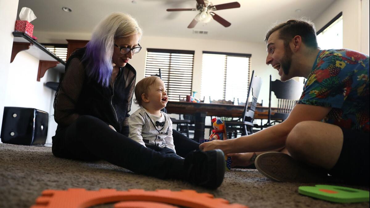 First-time homebuyers James Cunningham and Heather Mathiesen play with their son, Hugo, at home in Lancaster.