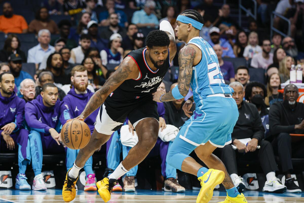 Clippers forward Paul George tries to drive around Hornets guard Tre Mann during the first half Sunday.