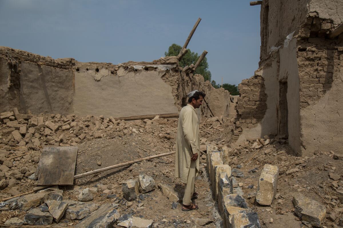 Badshah Dullah, 40, stands in what is left of his house that was hit by a U.S. airstrike 15 years ago. The family can't afford to repair it.