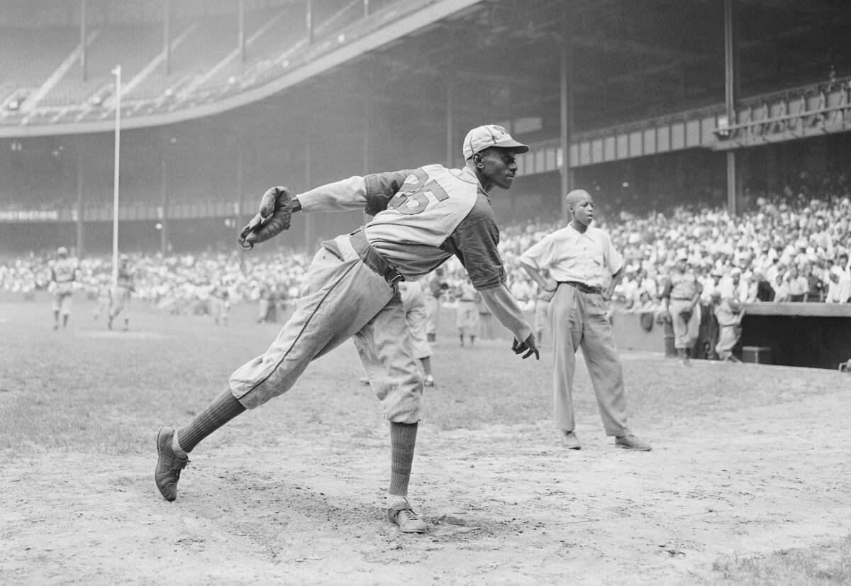 Kansas City Monarchs pitching great Leroy "Satchel" Paige warms up at New York's Yankee Stadium August 2, 1942.