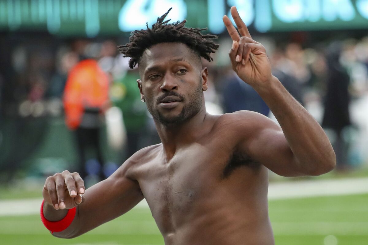 Tampa Bay Buccaneers wide receiver Antonio Brown gestures to the crowd as he leaves the field shirtless