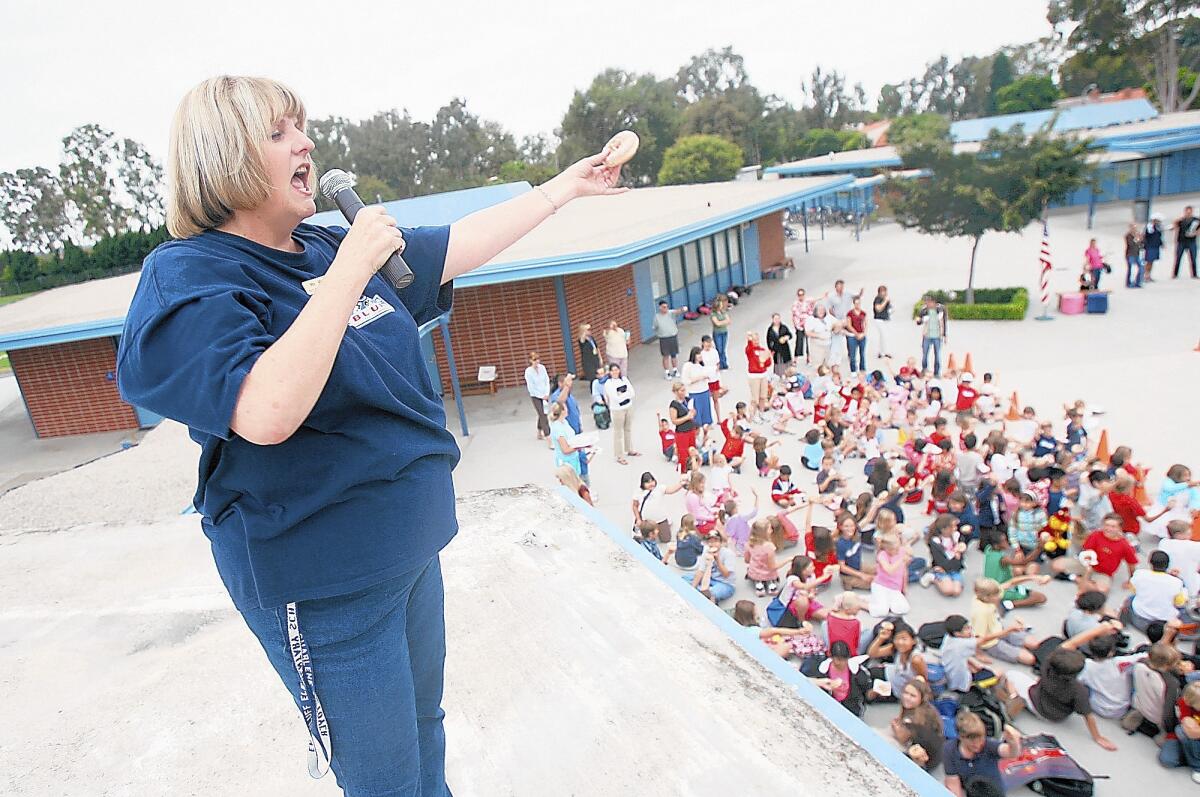 Principal Charlene Metoyer performs a "donut salute" to her sixth-grade class while standing atop the roof at Eastbluff Elementary School in 2006. Metoyer has announced she's running for school board.