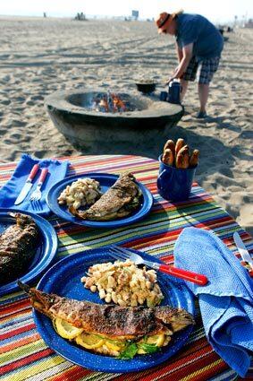 Whatever the activity, or lack thereof, a fabulous dinner is a great way to cap off a day outdoors. All that's needed is a campfire, a little planning, a skillet and a Dutch oven. Here, at Dockweiler State Beach, a camp menu includes pan-fried trout, white bean salad and buttermilk stick biscuits.