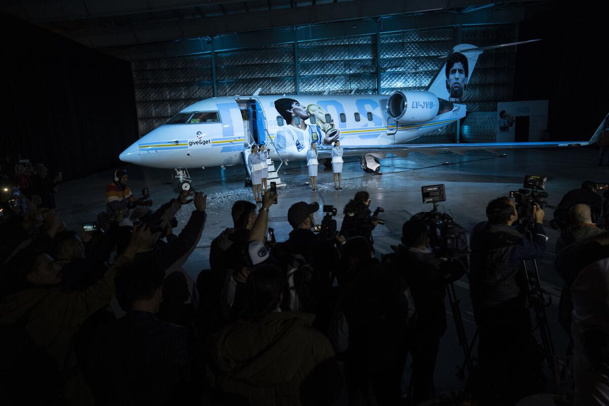 Un grupo de periodistas se congrega para la presentación del avión dedicado al fallecido astro del fútbol Diego Maradona
