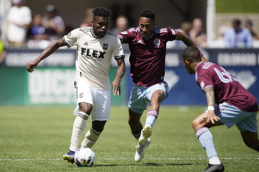 Los Angeles FC midfielder José Cifuentes, left, drives past Colorado Rapids defenders Auston Trusty.