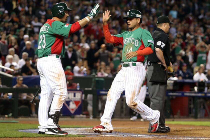 Adrian Gonzalez, left, greets Mexican squad teammate Eduardo Arredondo at the plate. With Mexico eliminated from the World Baseball Classic, Gonzalez will return to the Dodgers on Monday.