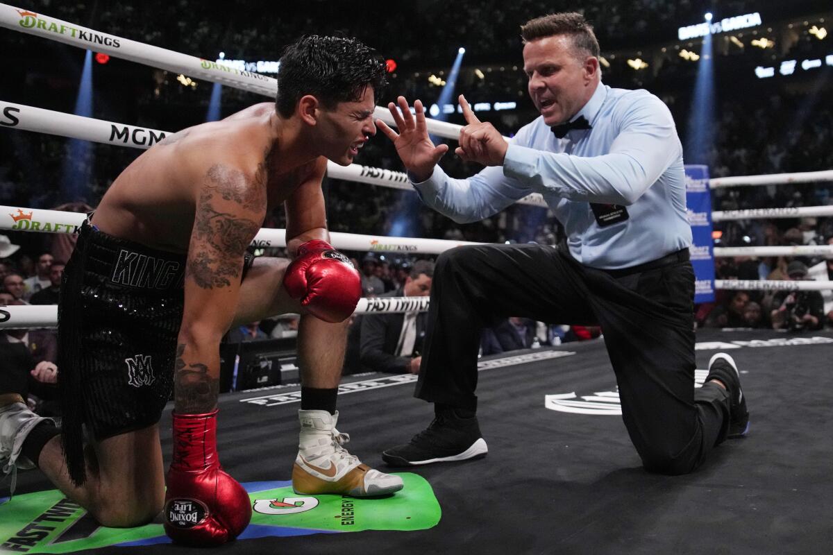 Referee Thomas Taylor counts out Ryan Garcia, who took a knee and lost after taking a body blow.