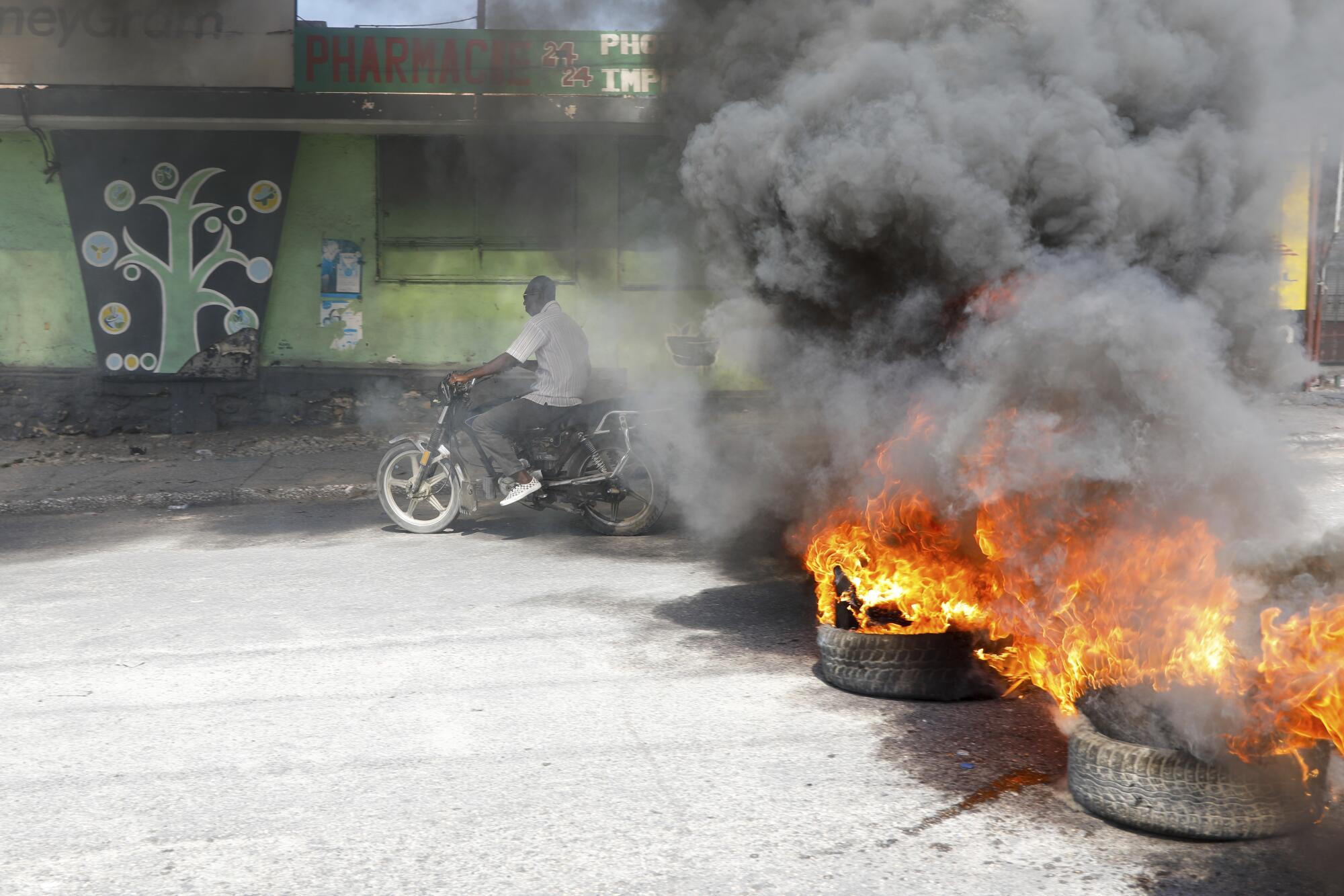 Un motociclista pasa junto a neumáticos en llamas durante una protesta para 