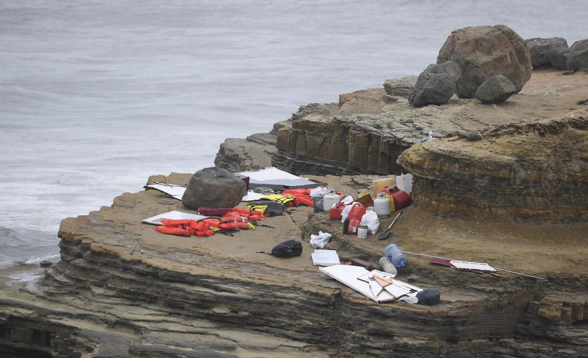 Items from a boat sit on the shoreline near where the vessel capsized just off the San Diego coast.