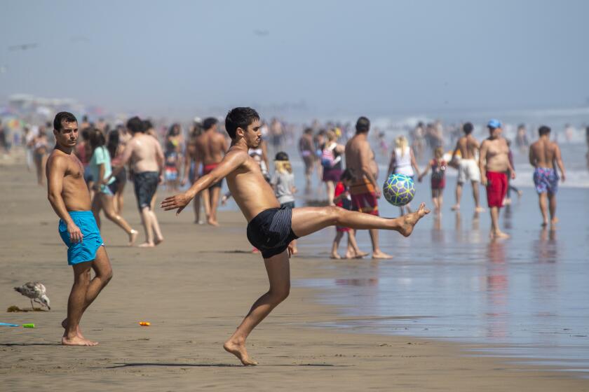 HUNTINGTON BEACH, CA - JUNE 10: Beach goers recreate at the water's edge to cool off amid high temperatures Wednesday, June 10, 2020 in Huntington Beach, CA. A heat advisory will be in effect today from 11 in the morning until 7 tonight throughout Southern California. (Allen J. Schaben / Los Angeles Times)