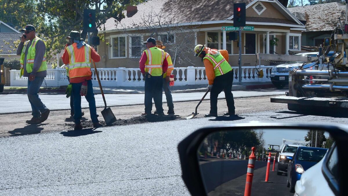 Workers repave a road in South Pasadena.