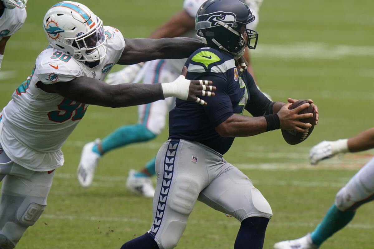 Miami Dolphins defensive end Shaq Lawson tries to bring down Seattle Seahawks quarterback Russell Wilson.