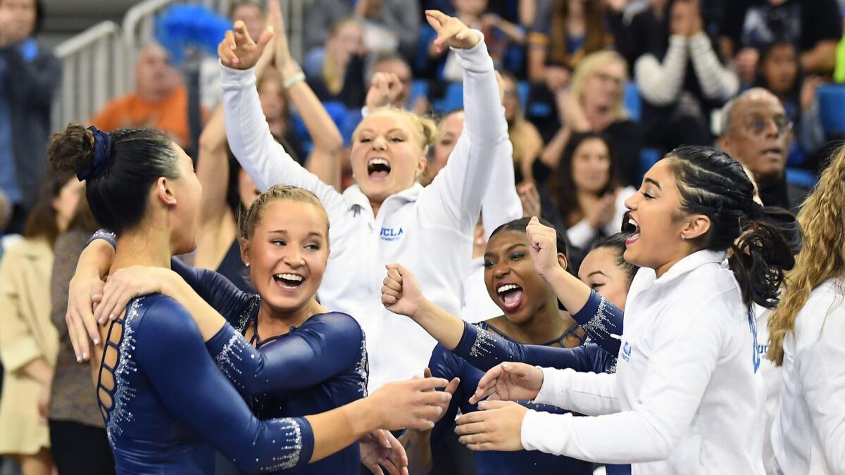 Kyla Ross, left, is mobbed by teammates after her perfect score on the beam against Stanford on March 10 at Pauley Pavillion.