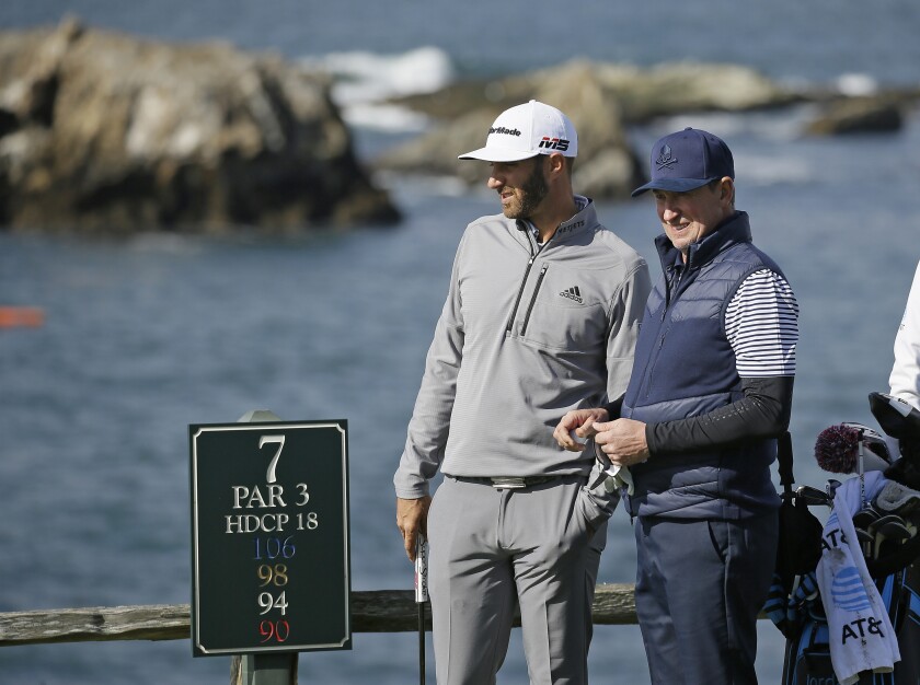 FILE - In this Saturday, Feb. 9, 2019, file photo, Dustin Johnson, left, and Wayne Gretzky stand on the seventh tee of the Pebble Beach Golf Links during the third round of the AT&T Pebble Beach Pro-Am golf tournament, in Pebble Beach, Calif. The Feb. 11-14 tournament will not have celebrities for the first time because of the COVID-19 pandemic. (AP Photo/Eric Risberg, File)