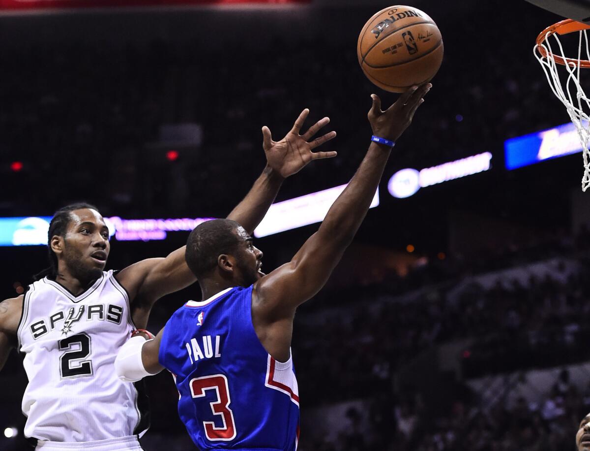 Spurs forward Kawhi Leonard tries to block the shot of Clippers guard Chris Paul from behind during the first half of Game 6.