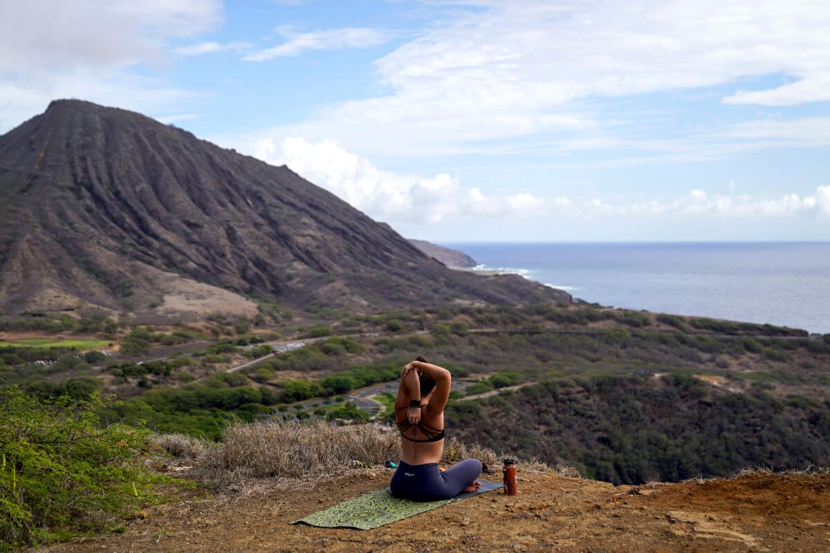 Jessica Linster practices yoga along a hiking trail overlooking Hanauma Bay. Koko Head is in the background.