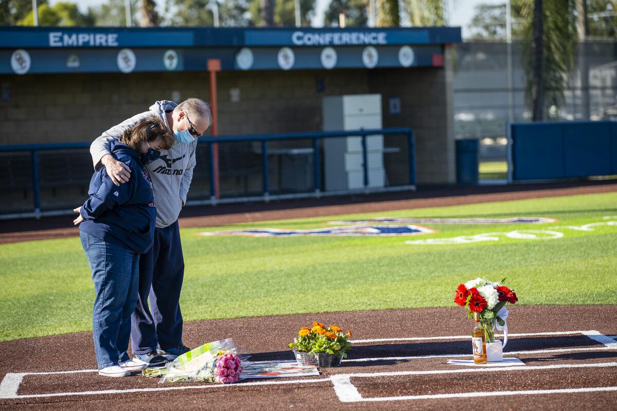 Sissy and Craig Oberlin, John Altobelli's sister and brother-in-law, look at a memorial at  at OCC baseball field Tuesday.