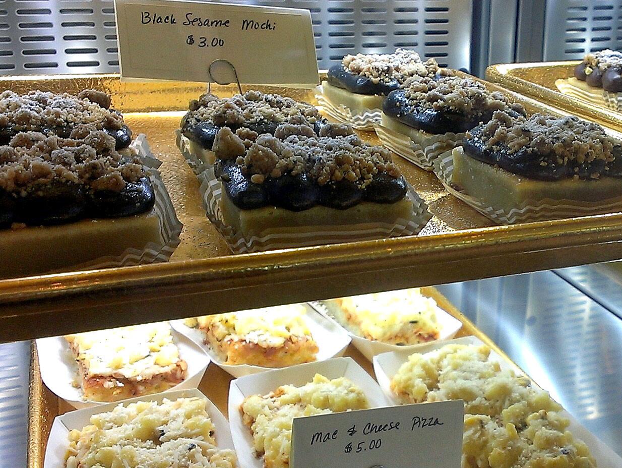 A mochi cake is covered with black sesame and streusel topping.