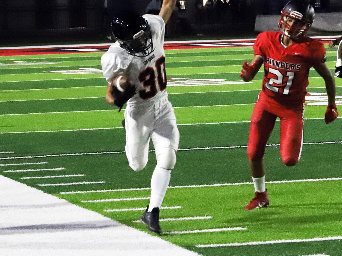 Los Amigos running back Isaac Galindo (30) runs along the sideline against Artesia in a nonleague game on Friday.