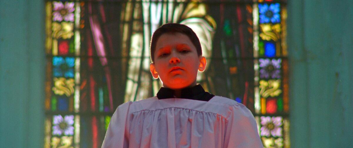 An altar boy stands in a church in the documentary "Procession."