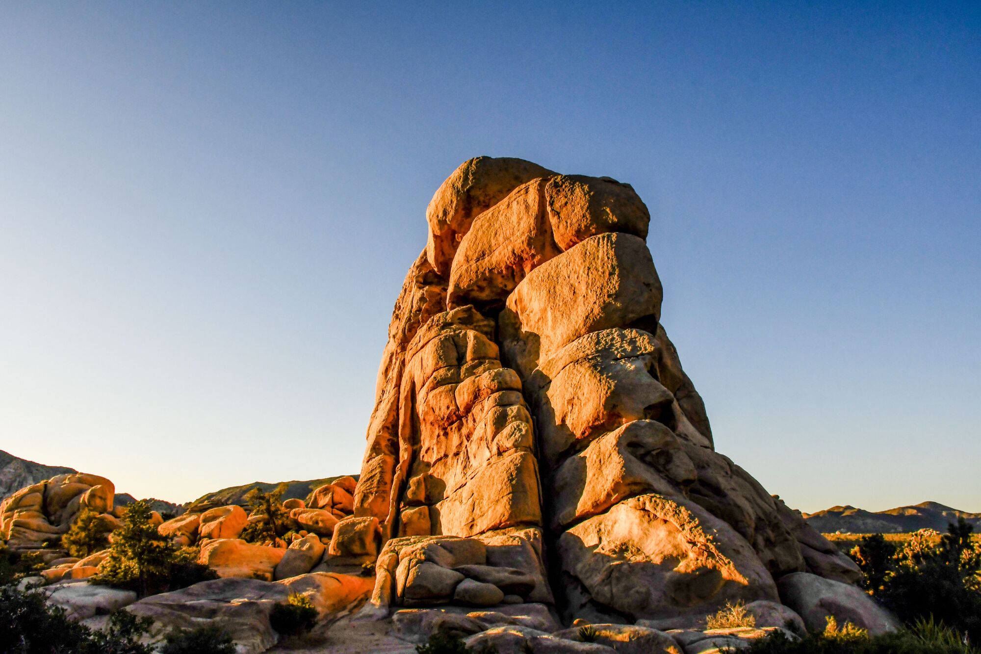 Reddish boulders stand out against a blue sky.