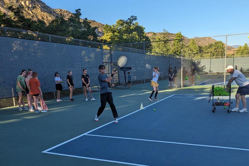 Roger Zetterberg and Elizbeth Nair working with Coach Troy Romero in the advanced group at the Bulldawgs tennis camp.