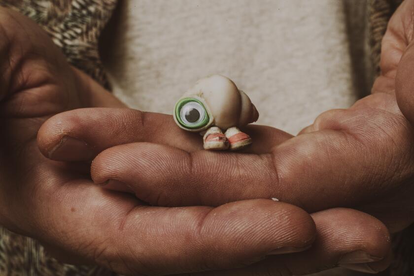 West Hollywood, CA - June 10: Dean Fleischer-Camp, director for "Marcel the Shell with Shoes on", holds Marcel in his hands at Quixote Studios in West Hollywood on Friday, June 10, 2022. "Marcel The Shell." Marcel is an adorable, 1-inch-tall shell who ekes out a colorful existence with his grandmother, Connie, and their pet lint, Alan. Once part of a sprawling community of shells, they now live alone as the sole survivors of a mysterious tragedy. However, when a documentary filmmaker discovers them, the short film he posts online brings Marcel millions of passionate fans, as well as unprecedented dangers and new hope of finding his long-lost family. (Allen J. Schaben / Los Angeles Times)