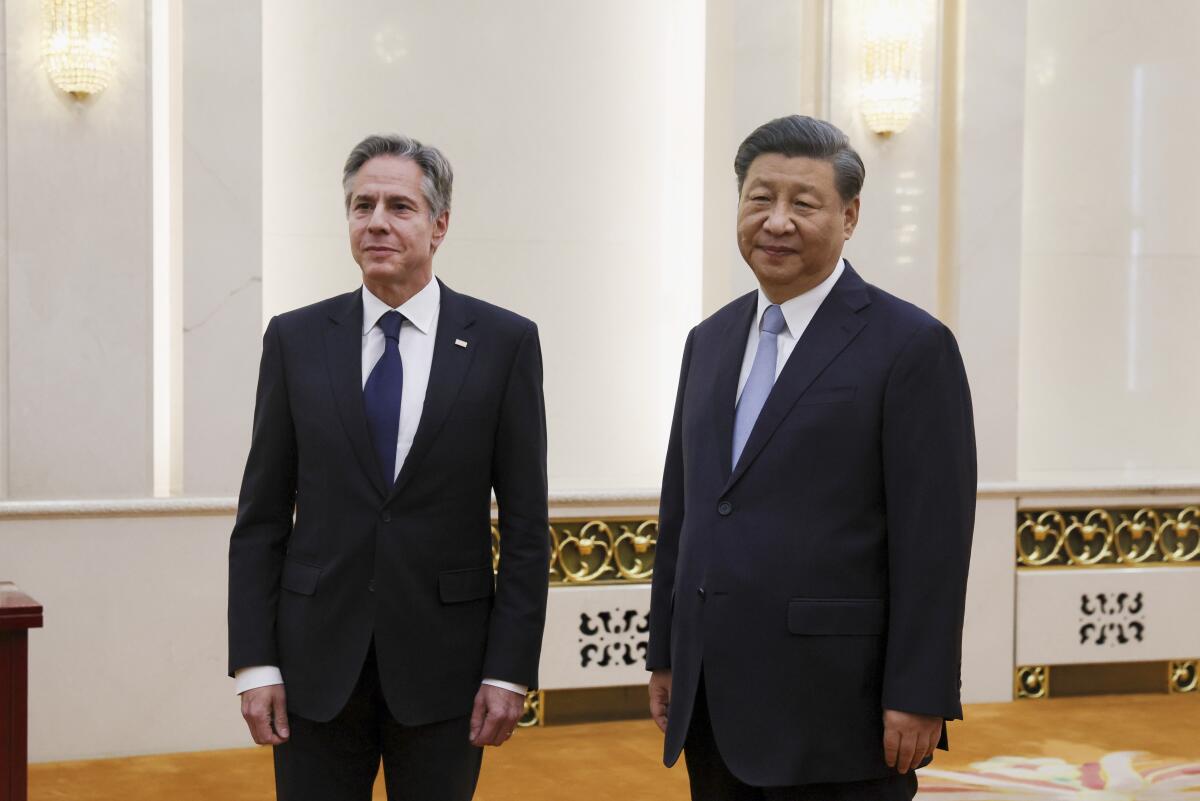Antony Blinken stands in a room with Xi Jinping.