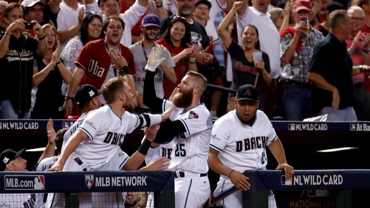Arizona Diamondbacks pitcher Archie Bradley (25) celebrate his two-run triple against the Colorado Rockies during the seventh inning of the National League wild-card game, on Wednesday.