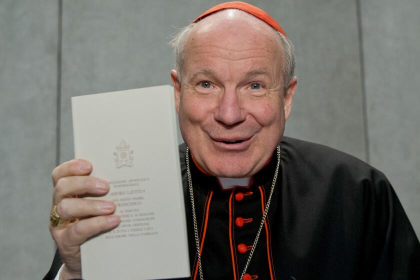 Cardinal Christoph Schoenborn holds a copy of Pope Francis' "Amoris Laetitia" during a news conference at the Vatican on April 8.