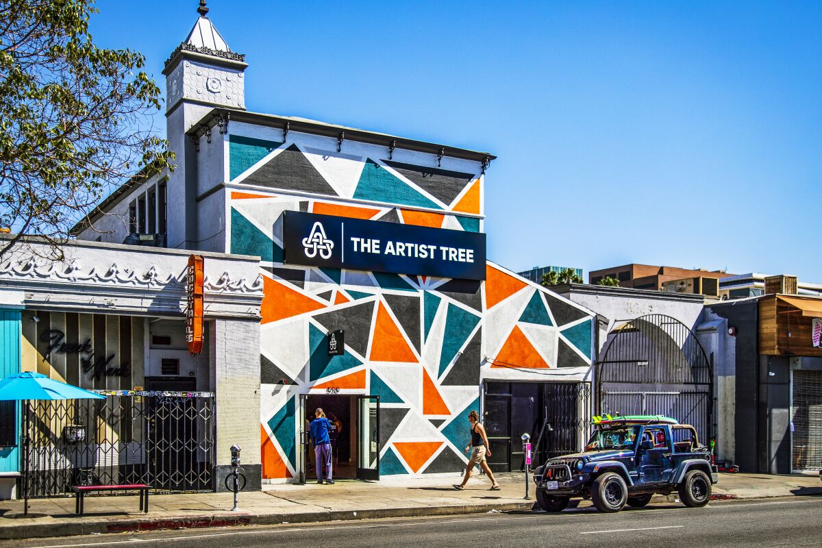 A colorful, geometric mural covers the front of a dispensary on Western Avenue.