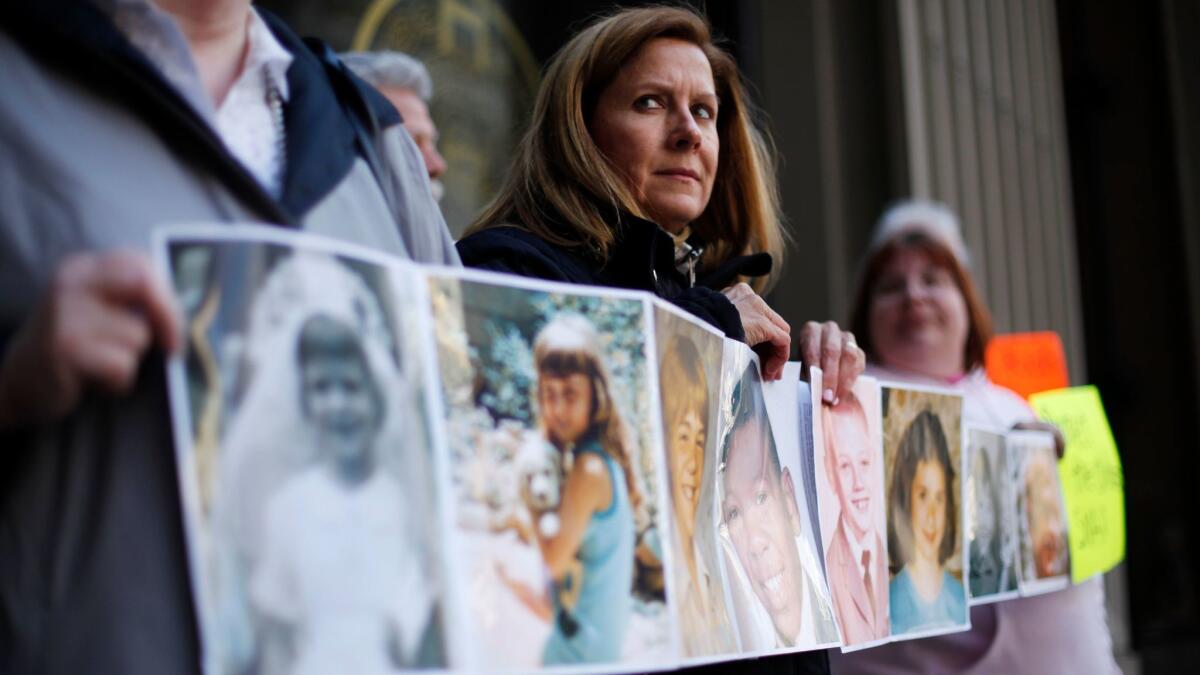 Barbara Blaine, then-president of Survivors Network of those Abused by Priests, displays childhood photographs of adults who say they were sexually abused, during a 2011 news conference in Philadelphia.