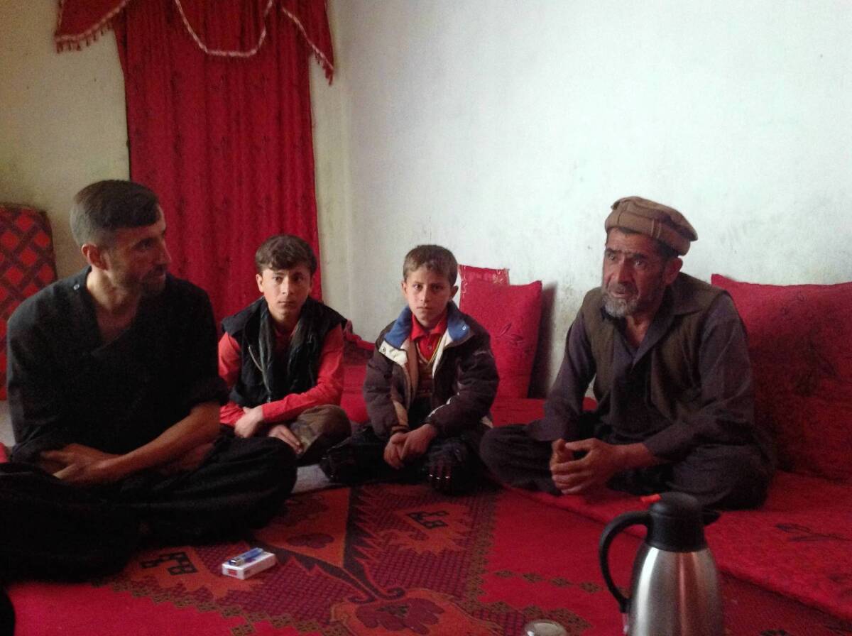 Jan Agha, right, is shown with his nephew, left, his son and his grandson in the Afghan village of Naqi Khail, as they mourn the death of Agha's son Zabiulla.