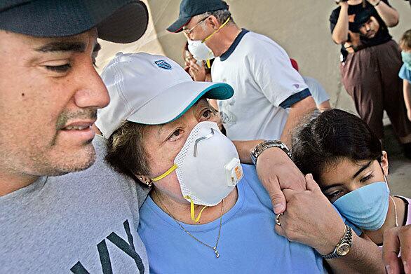 Adries Rios, left, comforts his mother, Mary Rios, who lost her home in the fire at Sylmar's Oakridge Mobile Home Park. At right is her grandaughter Jacqueline Rios, 9. It is the third time that Mary Rios and her husband have lost their home. They also were displaced in the 1971 Sylmar earthquake and the 1994 Northridge earthquake.
