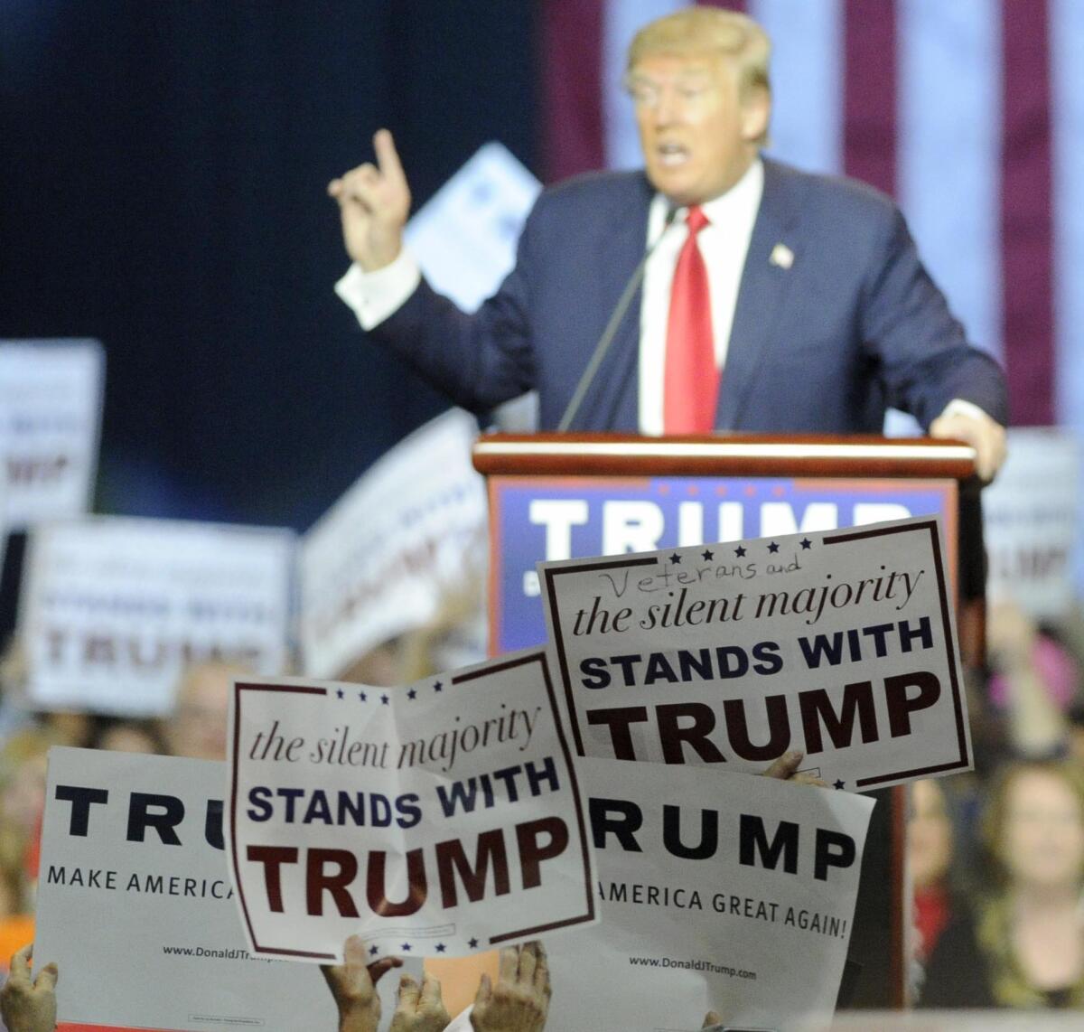 Fans show support as Republican presidential candidate Donald Trump speaks during a campaign stop Saturday in Birmingham, Ala. That his message of intolerance resonates says more about Americans than it does about Trump.