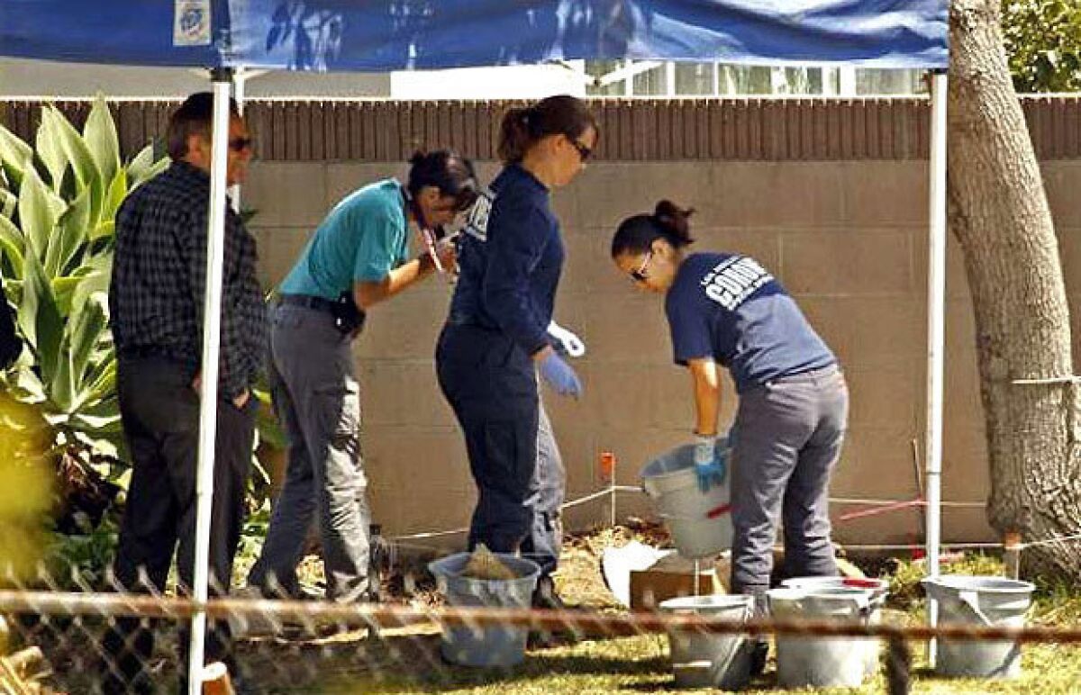 Ed Winter, assistant chief at the Los Angeles County Coroner's Office, left, works with investigators in the backyard of a home in Pico Rivera where Joseph Rubalcaba's body was found.