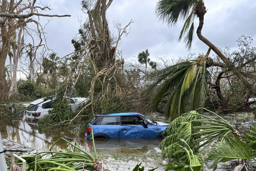In this undated image from video, damaged vehicles and debris are seen on Sanibel Island, Fla. Chuck Larsen's home was slammed by Hurricane Ian and he spent a harrowing few days on the isolated island before being evacuated over the weekend. (Chuck Larsen/SantivaChronicle.com via AP)