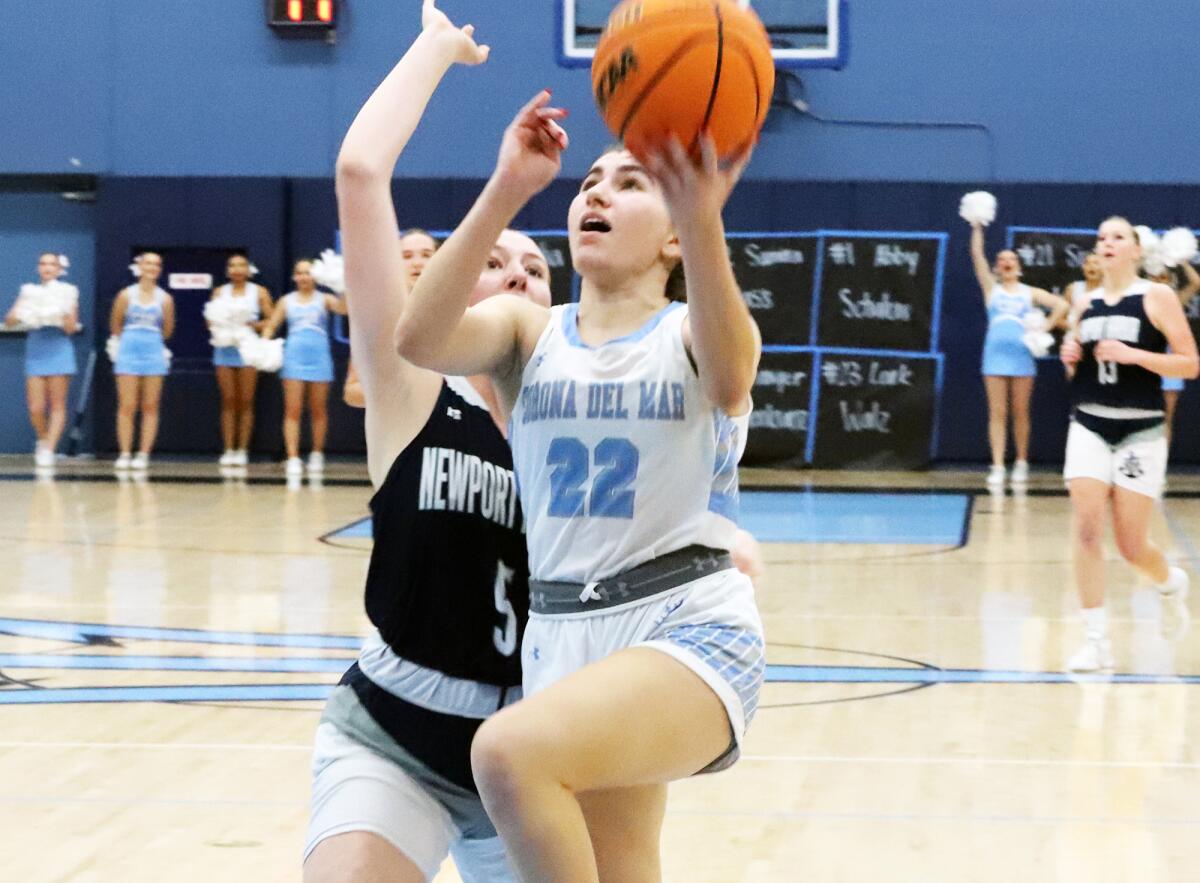 Corona del Mar's Julia Mork (22) drives to the basket against Newport Harbor.