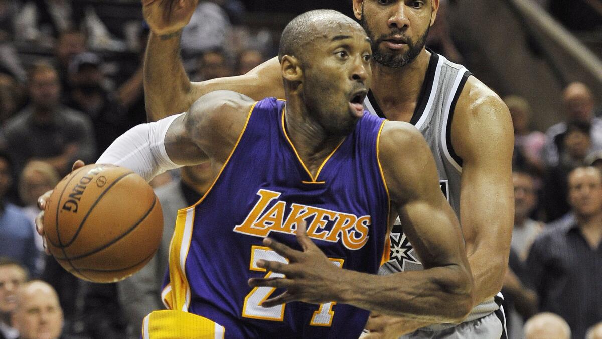 Lakers star Kobe Bryant, front, drives past San Antonio Spurs forward Tim Duncan during the Lakers' overtime win Friday.
